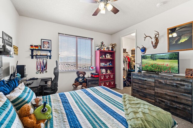 4024 Colina Roja Ln NE, Rio Rancho, NM 87124 - carpeted bedroom with a textured ceiling, a walk in closet, a ceiling fan, and a desk
