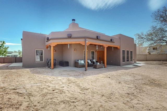 back of property featuring fence, an outdoor living space, a chimney, and a patio area