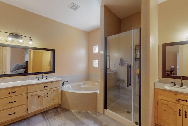 bathroom with a garden tub, a sink, and two vanities