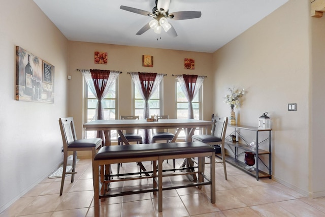 dining area with light tile patterned floors, baseboards, and ceiling fan