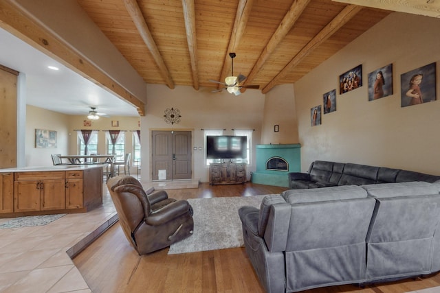 living room with a large fireplace, ceiling fan, wooden ceiling, and beam ceiling