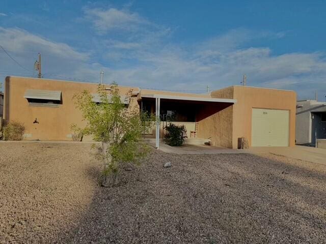 view of front facade featuring stucco siding, driveway, and a garage