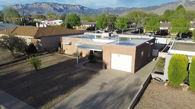 exterior space featuring driveway, a mountain view, and a garage