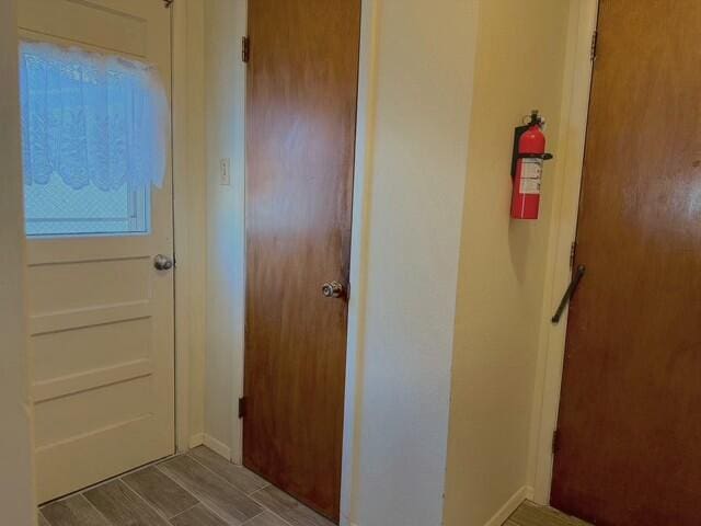 hall with baseboards and wood tiled floor