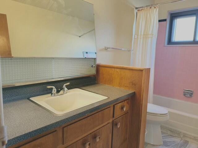 full bathroom with shower / bath combo with shower curtain, vanity, backsplash, and toilet
