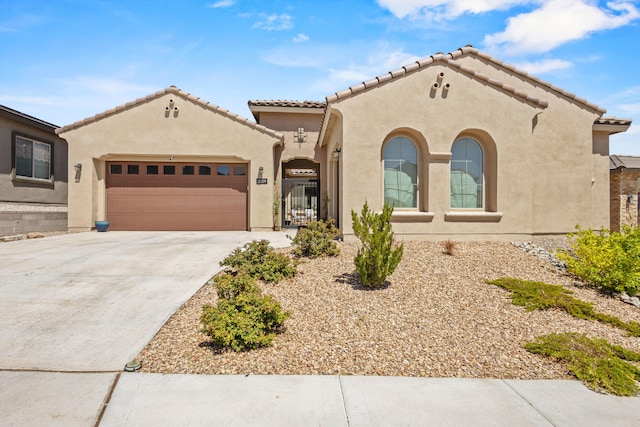 12209 Bear Valley Ln NW, Albuquerque, NM 87120 - mediterranean / spanish-style home with stucco siding, concrete driveway, a tiled roof, and a garage
