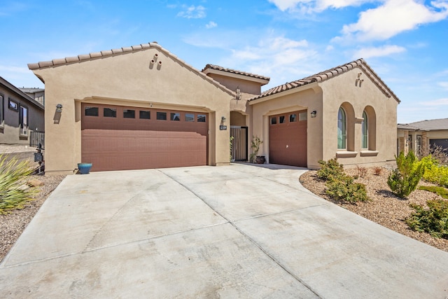 12209 Bear Valley Ln NW, Albuquerque, NM 87120 - mediterranean / spanish-style house featuring stucco siding, an attached garage, driveway, and a tile roof