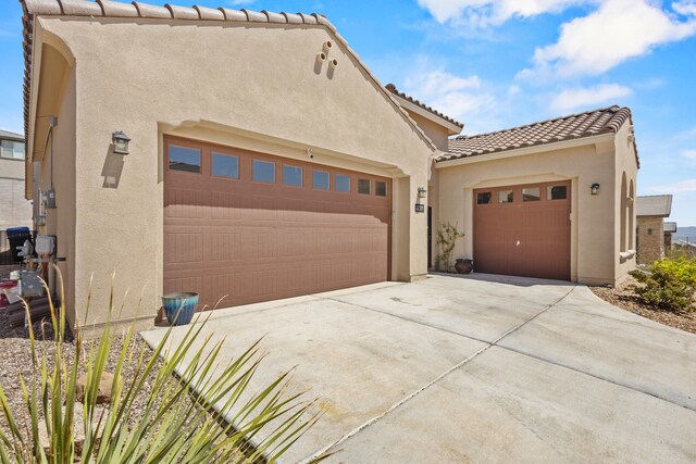 12209 Bear Valley Ln NW, Albuquerque, NM 87120 - view of front facade with a garage, a tile roof, concrete driveway, and stucco siding