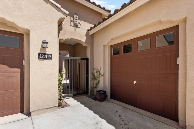 12209 Bear Valley Ln NW, Albuquerque, NM 87120 - entrance to property with stucco siding, a gate, a tiled roof, and a garage