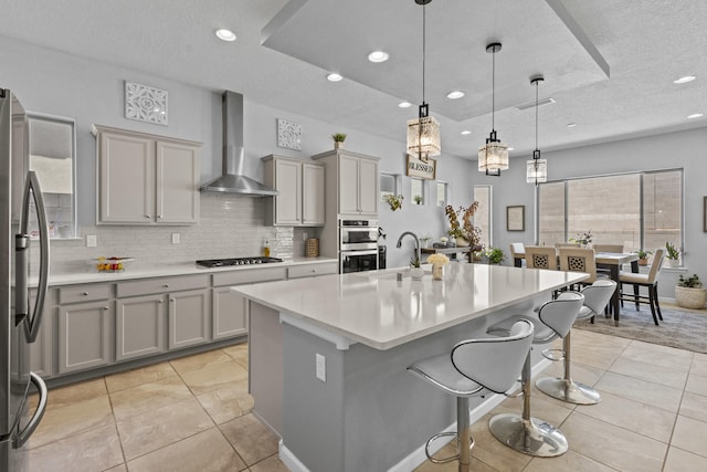 12209 Bear Valley Ln NW, Albuquerque, NM 87120 - kitchen featuring wall chimney exhaust hood, gray cabinets, stainless steel appliances, and a sink