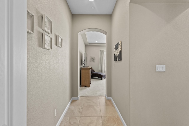 12209 Bear Valley Ln NW, Albuquerque, NM 87120 - hallway with arched walkways, a textured wall, and baseboards