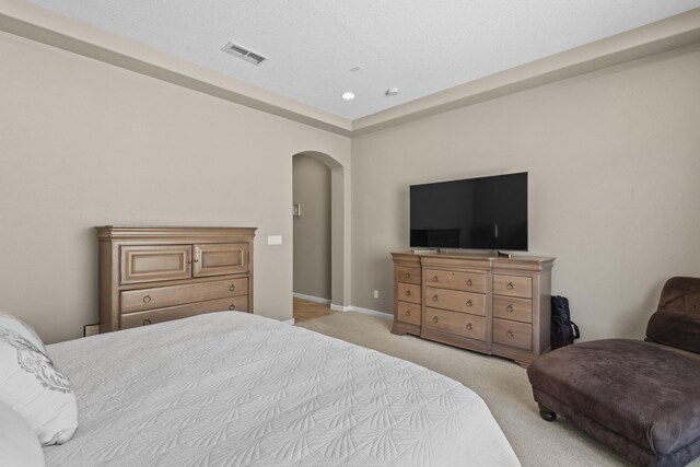 12209 Bear Valley Ln NW, Albuquerque, NM 87120 - bedroom with recessed lighting, visible vents, arched walkways, baseboards, and light colored carpet