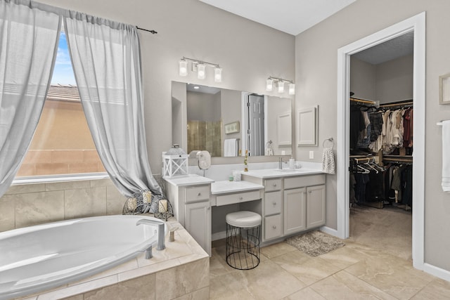 12209 Bear Valley Ln NW, Albuquerque, NM 87120 - bathroom with a walk in closet, a garden tub, vanity, and tile patterned flooring