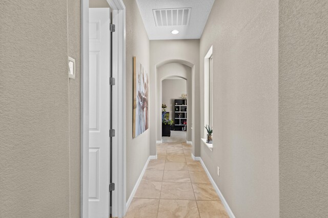 12209 Bear Valley Ln NW, Albuquerque, NM 87120 - hall with a textured wall, baseboards, visible vents, and marble finish floor
