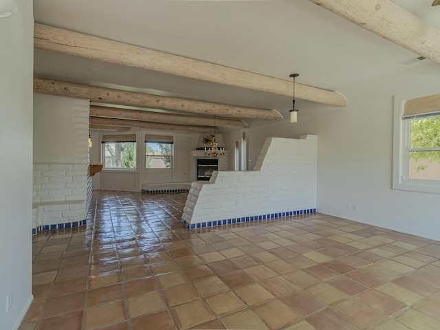7417 Maplewood Dr NW, Albuquerque, NM 87120 - unfurnished living room with a fireplace, beam ceiling, and a healthy amount of sunlight