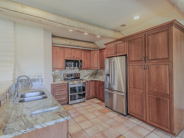7417 Maplewood Dr NW, Albuquerque, NM 87120 - kitchen featuring light stone counters, a sink, appliances with stainless steel finishes, brown cabinetry, and backsplash