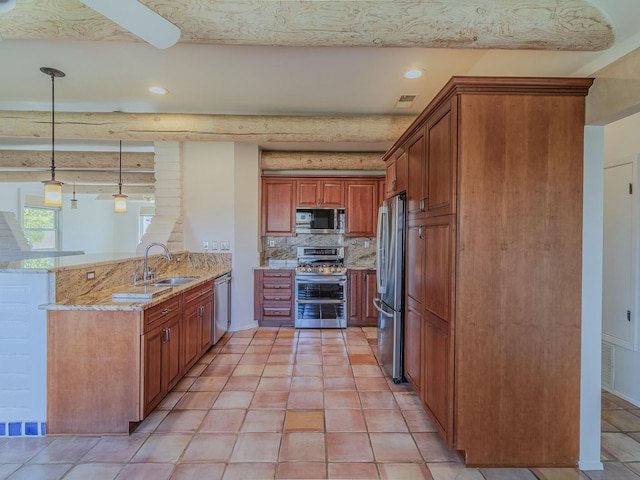 7417 Maplewood Dr NW, Albuquerque, NM 87120 - kitchen featuring light stone counters, a sink, brown cabinets, stainless steel appliances, and a peninsula