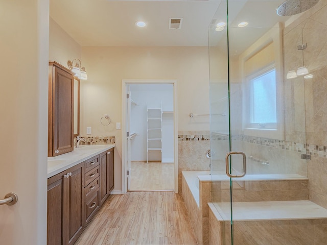 7417 Maplewood Dr NW, Albuquerque, NM 87120 - full bath with a bath, double vanity, visible vents, wood finished floors, and a shower stall