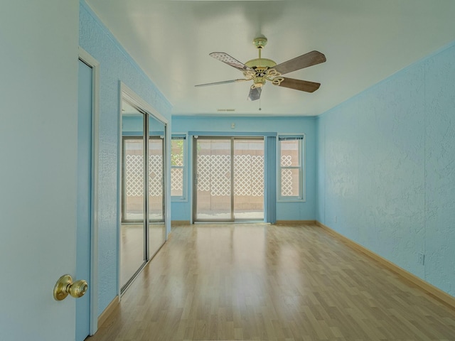 7417 Maplewood Dr NW, Albuquerque, NM 87120 - unfurnished room with a textured wall, baseboards, wood finished floors, and ceiling fan