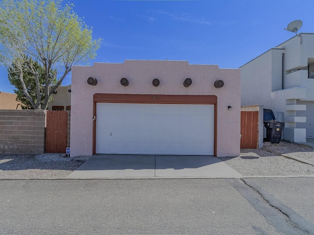 7417 Maplewood Dr NW, Albuquerque, NM 87120 - southwest-style home featuring a garage, concrete driveway, fence, and stucco siding