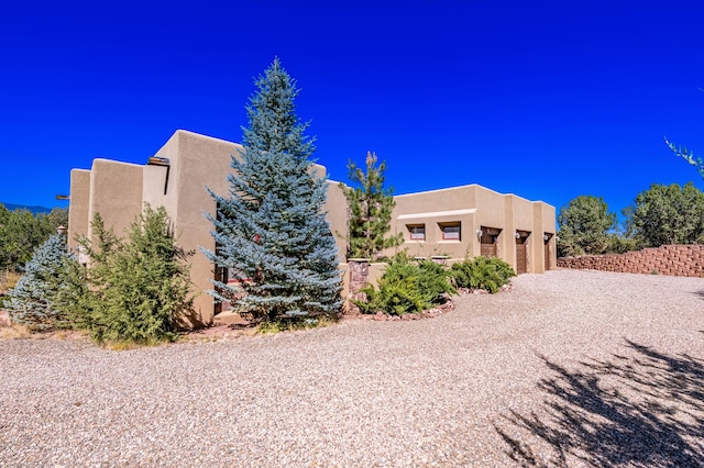 6 Storyteller Ct, Sandia Park, NM 87047 - view of side of property with stucco siding, driveway, and an attached garage