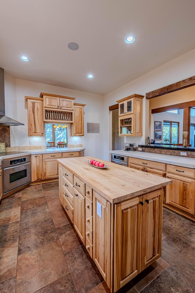 6 Storyteller Ct, Sandia Park, NM 87047 - kitchen with stainless steel oven, wooden counters, dark stone finish flooring, wall chimney exhaust hood, and recessed lighting