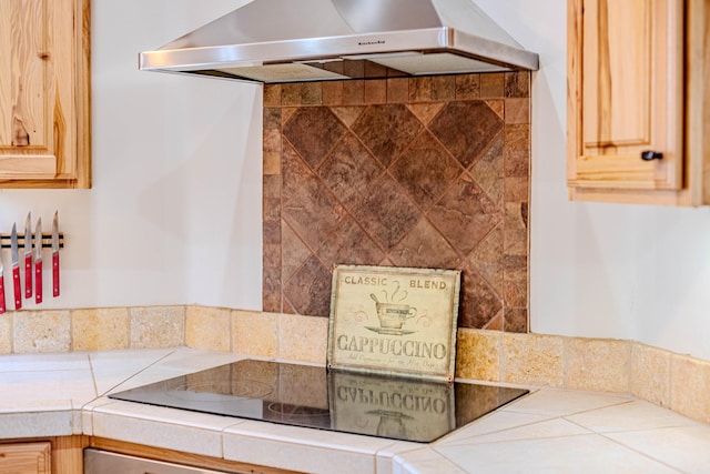 6 Storyteller Ct, Sandia Park, NM 87047 - kitchen with wall chimney range hood, tile counters, black electric cooktop, and light brown cabinets