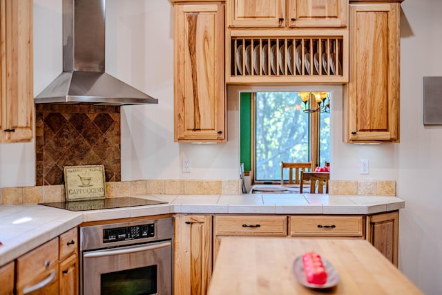 6 Storyteller Ct, Sandia Park, NM 87047 - kitchen with wall chimney range hood, stainless steel oven, backsplash, and black electric stovetop