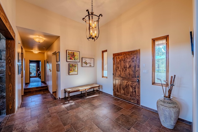 6 Storyteller Ct, Sandia Park, NM 87047 - foyer entrance with stone tile floors, a chandelier, and a towering ceiling
