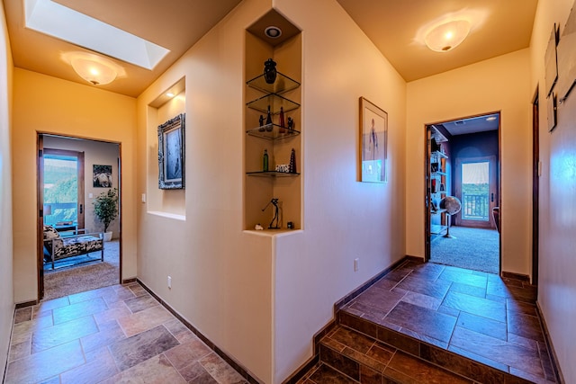 6 Storyteller Ct, Sandia Park, NM 87047 - corridor with stone tile flooring, a skylight, and plenty of natural light