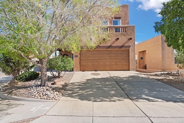 4201 High Mesa Rd SE, Rio Rancho, NM 87124 - pueblo revival-style home with driveway, stucco siding, and an attached garage