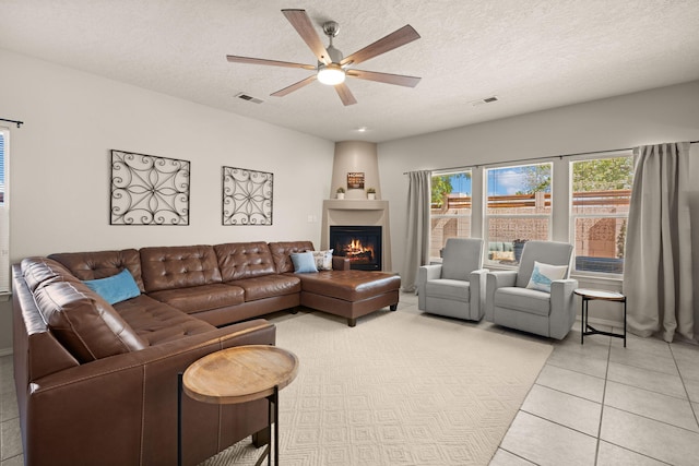 4201 High Mesa Rd SE, Rio Rancho, NM 87124 - living room with ceiling fan, a fireplace, light tile patterned floors, and a textured ceiling