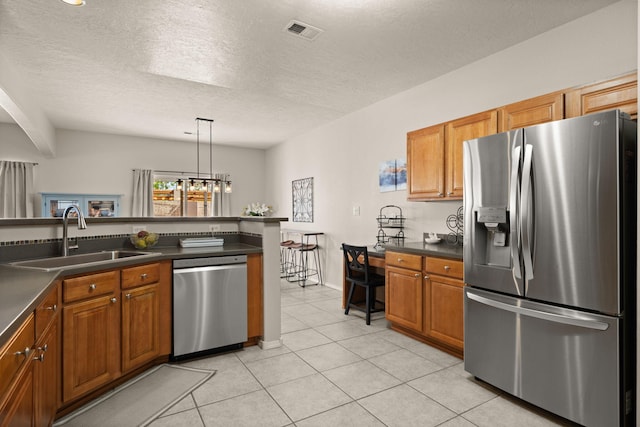 4201 High Mesa Rd SE, Rio Rancho, NM 87124 - kitchen featuring appliances with stainless steel finishes, a sink, dark countertops, brown cabinetry, and a textured ceiling