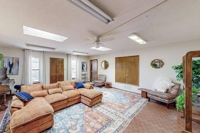 living room featuring visible vents, ceiling fan, and a skylight