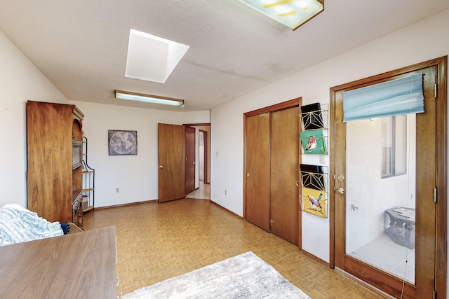 bedroom with a skylight, baseboards, and a closet