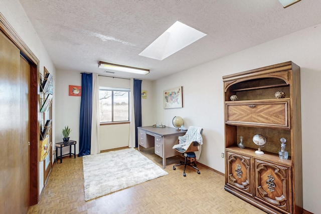 home office featuring baseboards, a textured ceiling, and a skylight