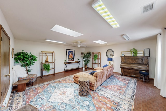 living room featuring visible vents, baseboards, and a skylight