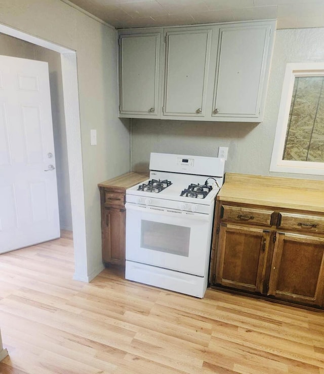 kitchen with light countertops, light wood-style flooring, and white gas stove