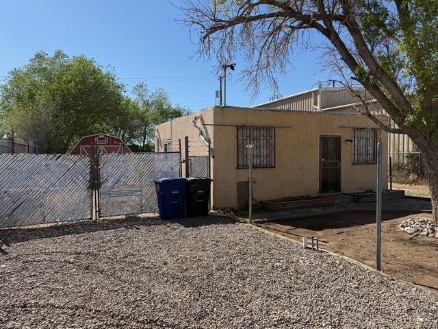 view of side of property featuring fence and stucco siding