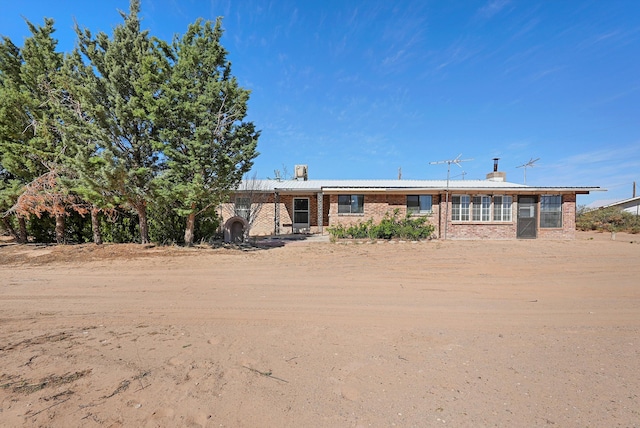 ranch-style home with brick siding and a chimney