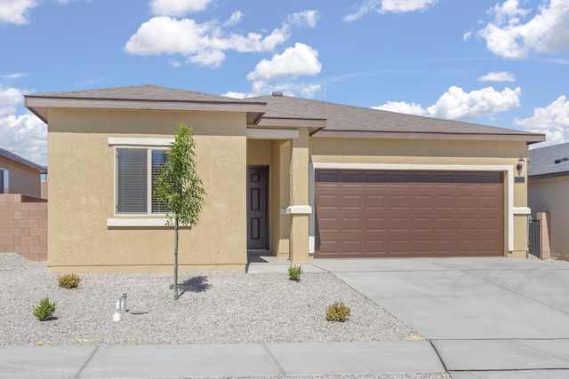 prairie-style house with a garage, stucco siding, and driveway