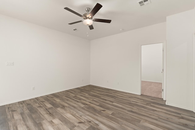 empty room with visible vents, ceiling fan, and wood finished floors