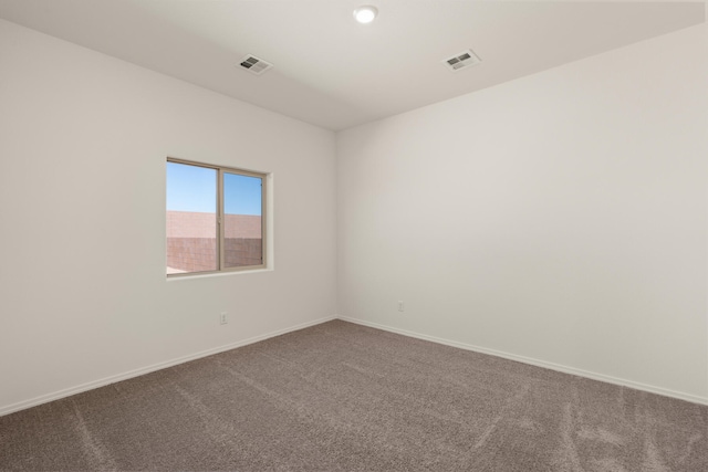 carpeted empty room featuring visible vents and baseboards