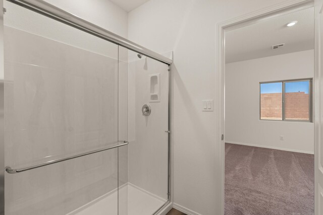bathroom featuring baseboards, a shower stall, and visible vents