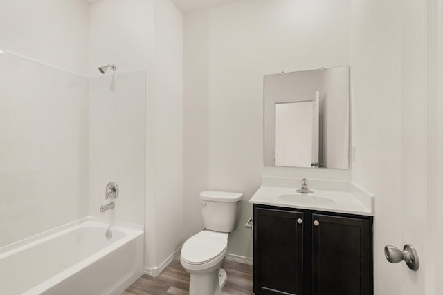bathroom with bathtub / shower combination, wood finished floors, vanity, baseboards, and toilet