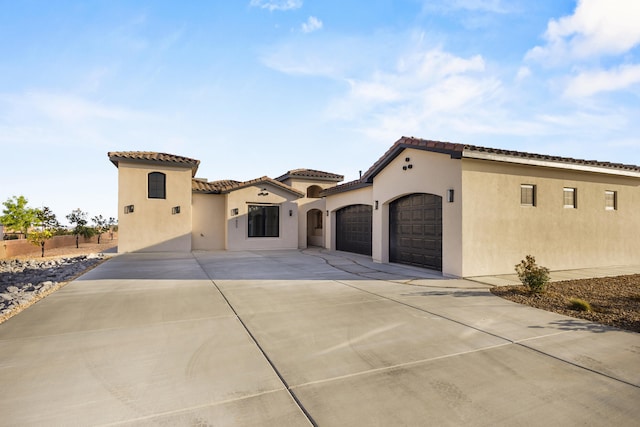7805 Aguila St NW, Albuquerque, NM 87120 - mediterranean / spanish-style home with a garage, a tile roof, driveway, and stucco siding