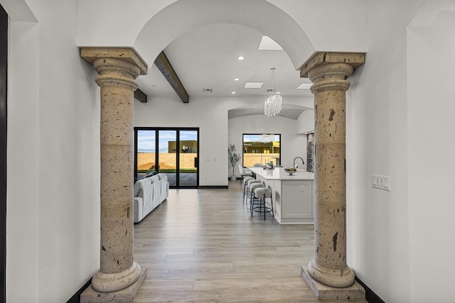 7805 Aguila St NW, Albuquerque, NM 87120 - hallway featuring recessed lighting, ornate columns, an inviting chandelier, light wood-style floors, and beam ceiling