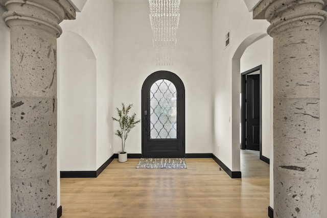 7805 Aguila St NW, Albuquerque, NM 87120 - entrance foyer with arched walkways, baseboards, visible vents, a chandelier, and wood finished floors