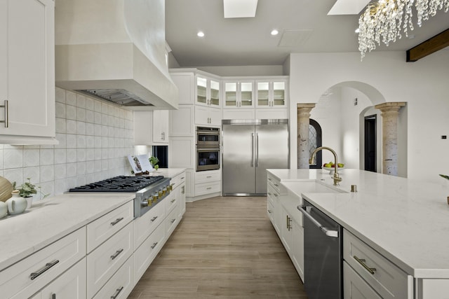 7805 Aguila St NW, Albuquerque, NM 87120 - kitchen with white cabinets, a sink, decorative backsplash, appliances with stainless steel finishes, and custom exhaust hood