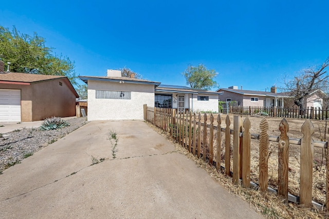 ranch-style house with roof mounted solar panels, fence private yard, and stucco siding